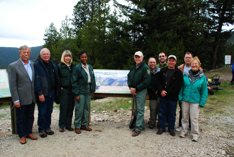 a group of people standing outside in front of a sign