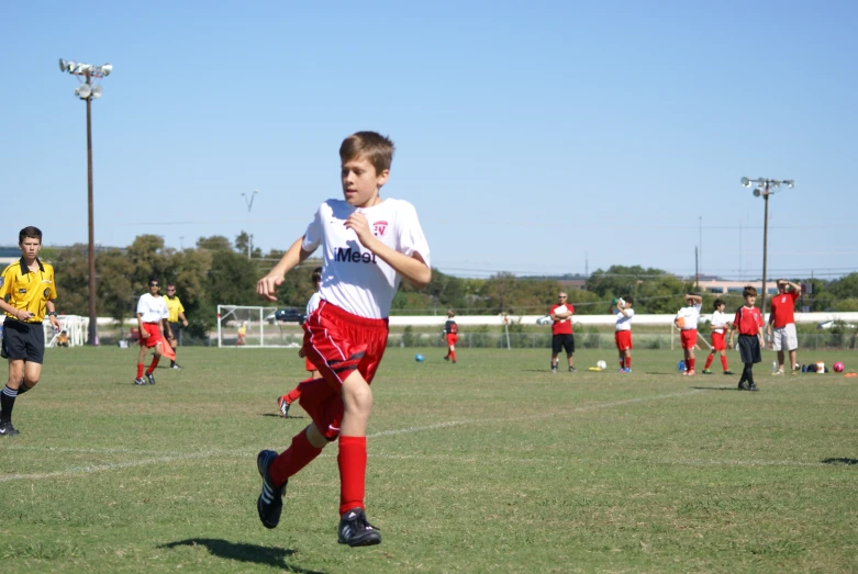 two young soccer players running across the field