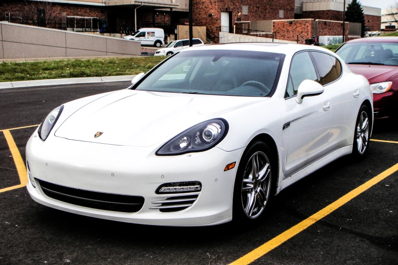 the white sports car is parked in the parking lot