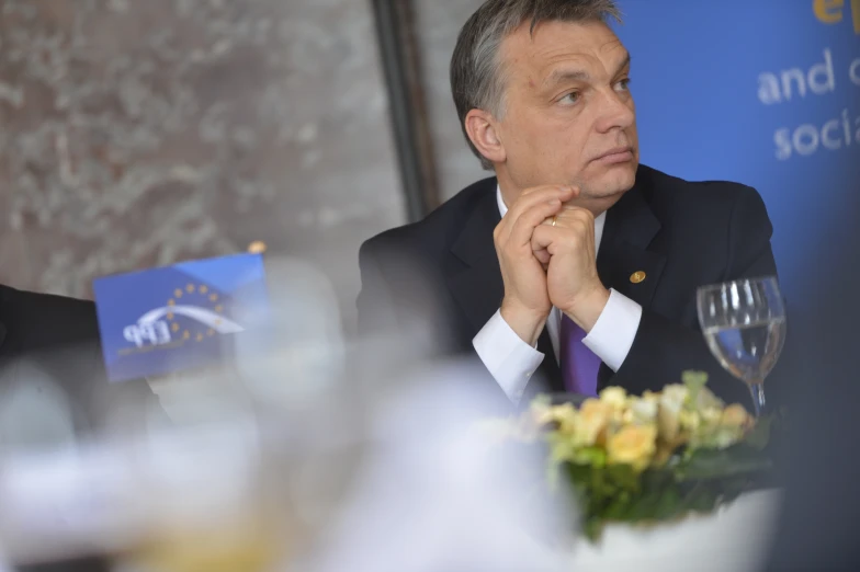 a man is sitting at a table staring off to his right