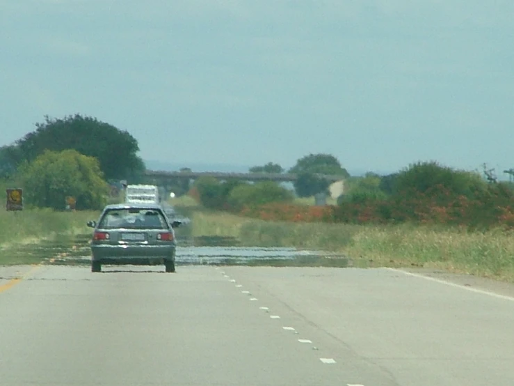 a car traveling down a road with water coming off it's sides