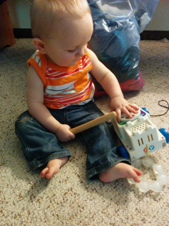 small baby playing with a toy on the floor