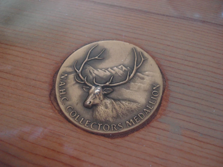 a medal with a deer head and name etched into it