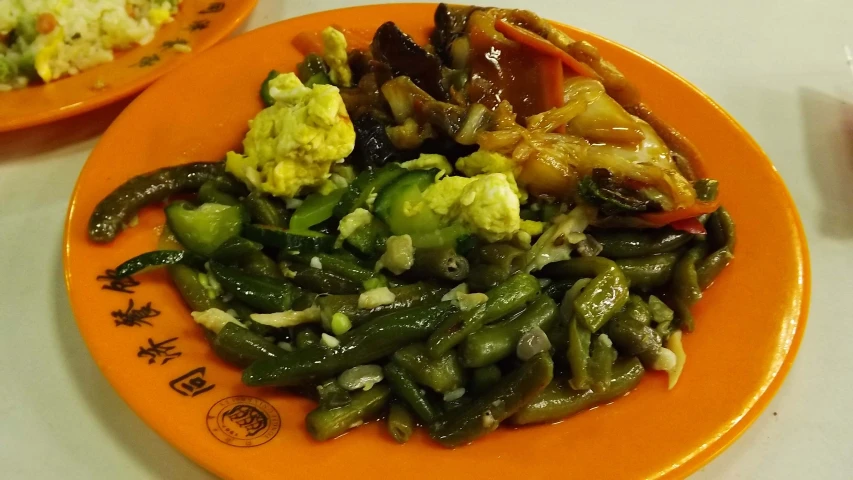 an orange plate filled with various types of vegetables