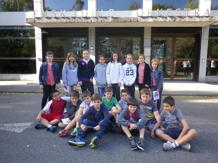 group of children in front of large building posing for pograph