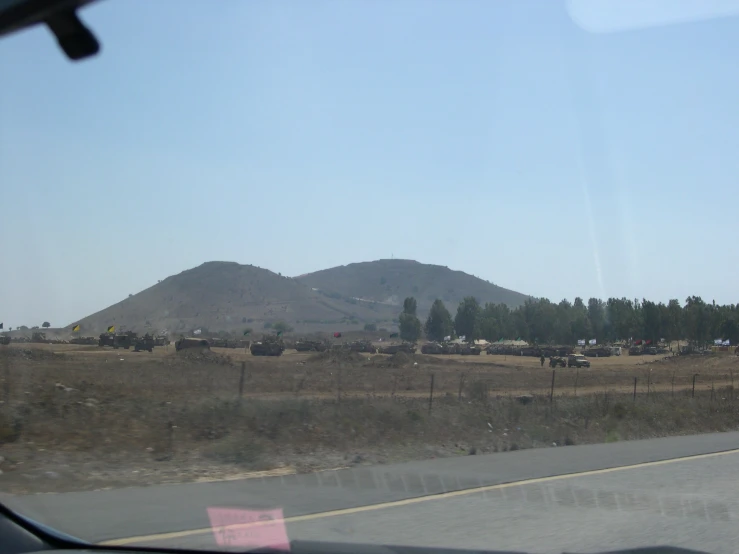 a road and a farm in front of a mountain