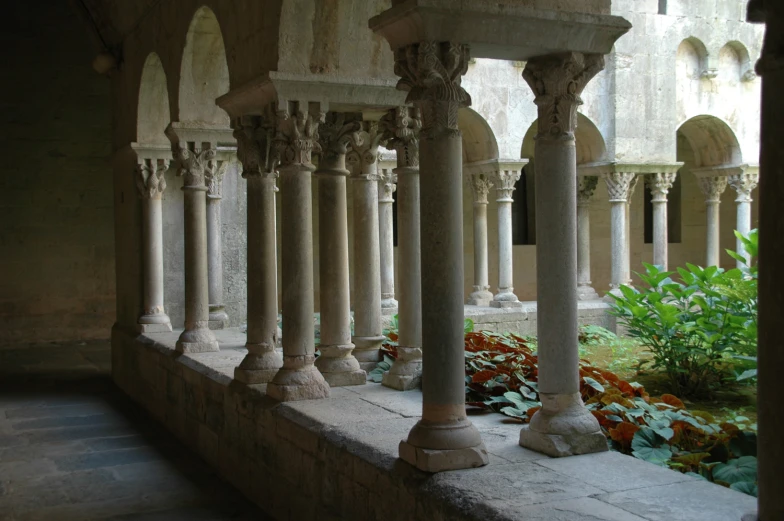 a balcony with several stone pillars and flowers