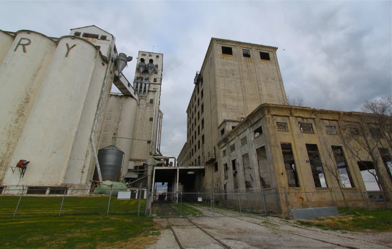 large factory building with multiple stories, near the green grass