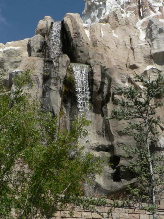 a waterfall cascades down over the side of a rock wall