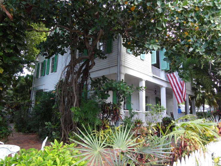 a house with white trim and green shutters on the front