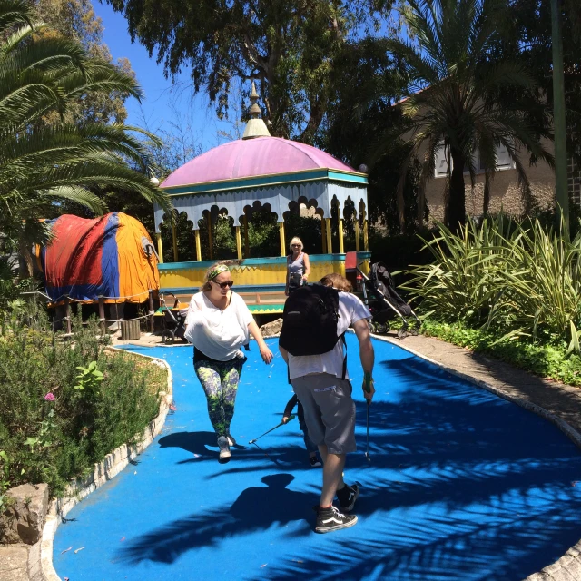 a person holding onto their skis walking on blue walkway