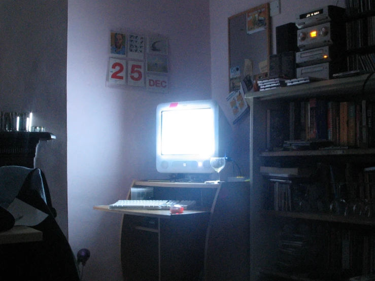 a computer desk with a monitor and keyboard sitting in a room