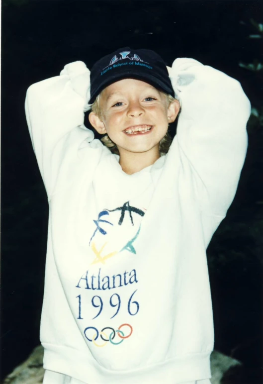 the boy smiles in his pajamas and cap