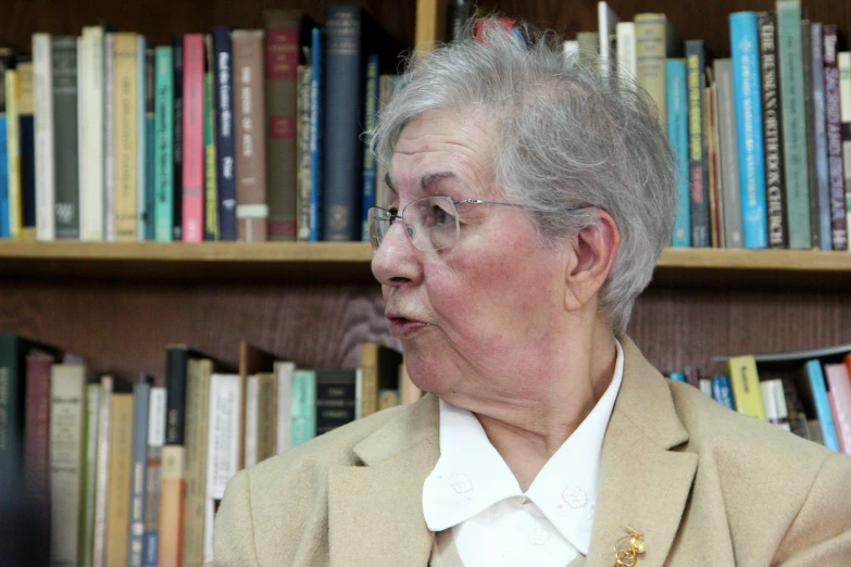 an older woman is in front of bookshelves