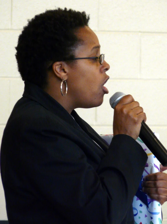 the woman is speaking into the microphone on stage