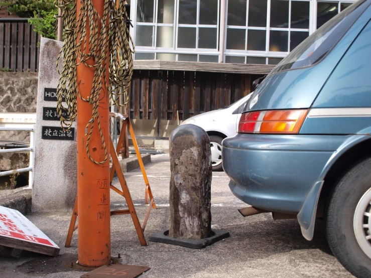 a van and a large metal statue next to a tree