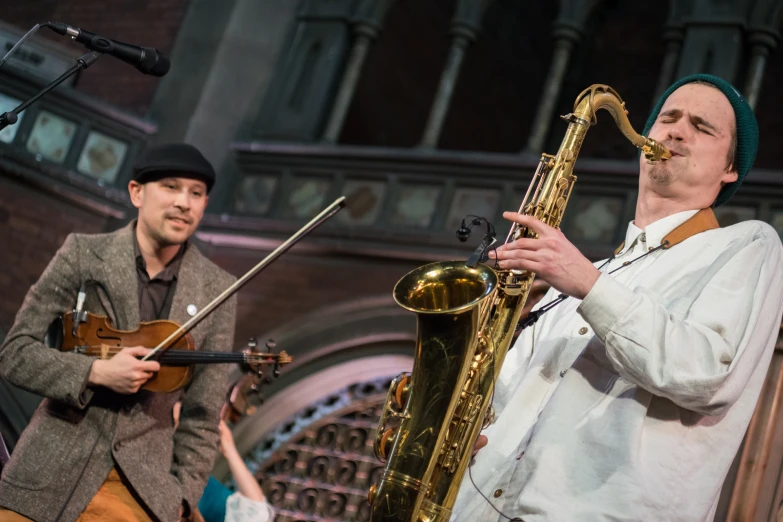 two people are playing instruments and singing