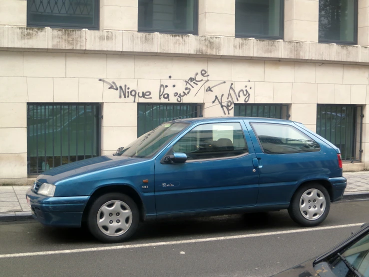 a blue car parked on the side of a road