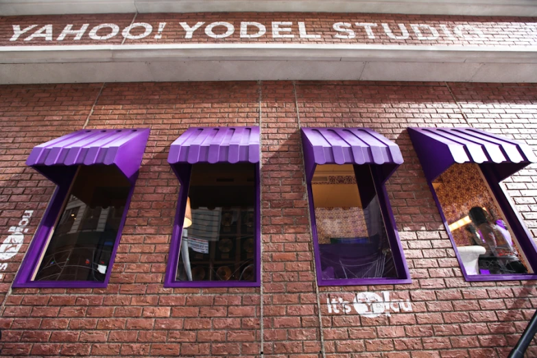 purple window covers hang from the side of a building