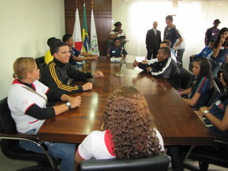 people sit around a conference table together in front of others