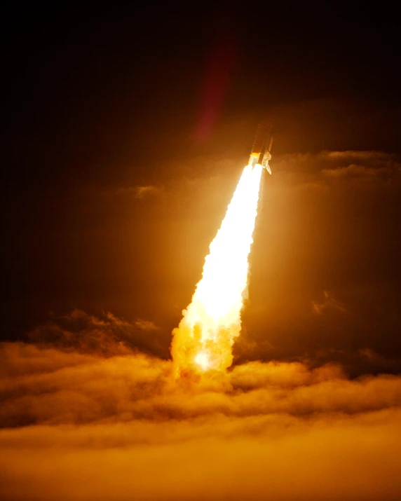 a rocket is launching into the sky in clouds