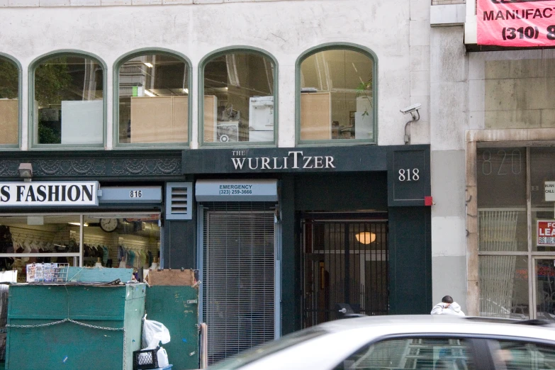 a car driving past a window and building with signs