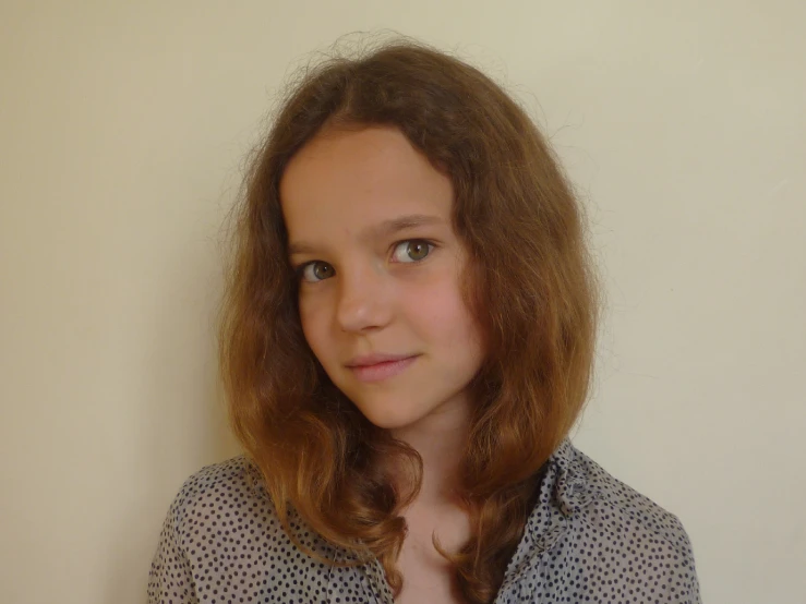 girl with long hair in blue shirt posing for camera