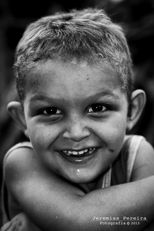 a black and white image of a smiling boy