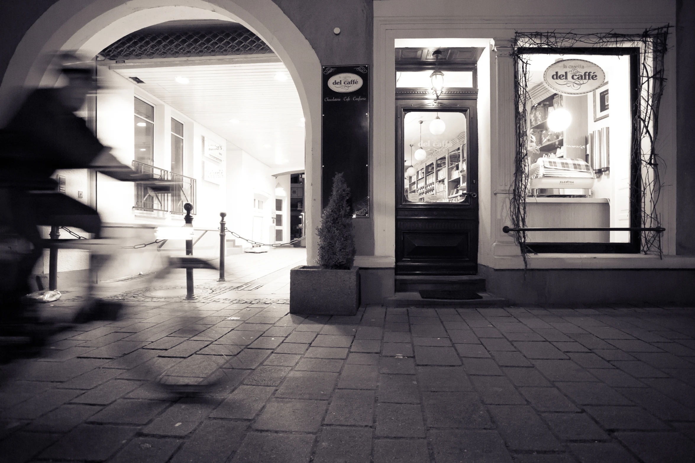 an empty sidewalk with a few shop windows