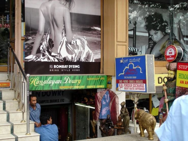 a couple of people sitting on a ledge in front of some signs