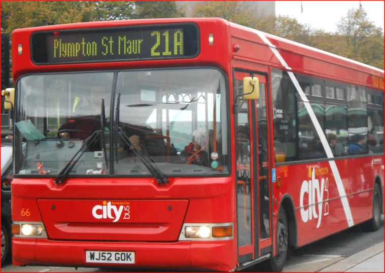 the large city bus is parked in front of a building