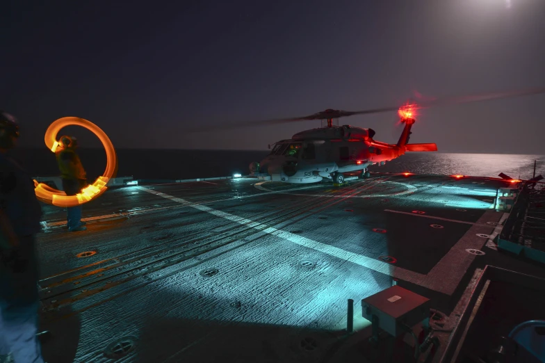 helicopter on top of the deck at night near a fire hydrant