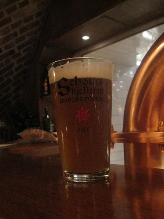 a glass of beer on top of a wooden table