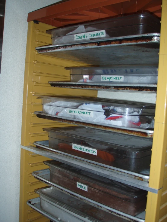 the shelving is full of trays that have trays with food in them