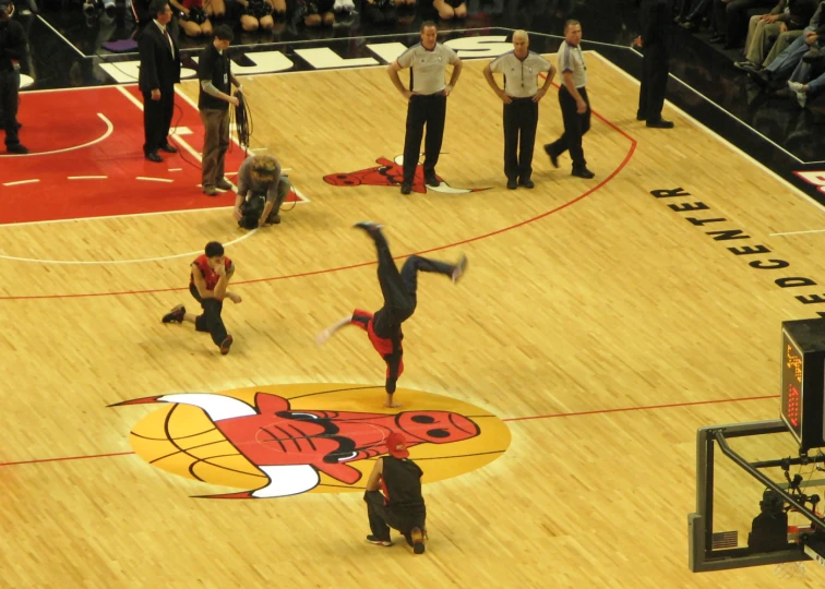 a person performs an aerial trick in the air on a basketball court