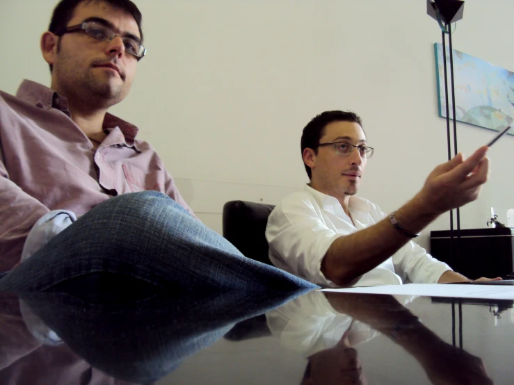 a man and another man are looking at soing on a table