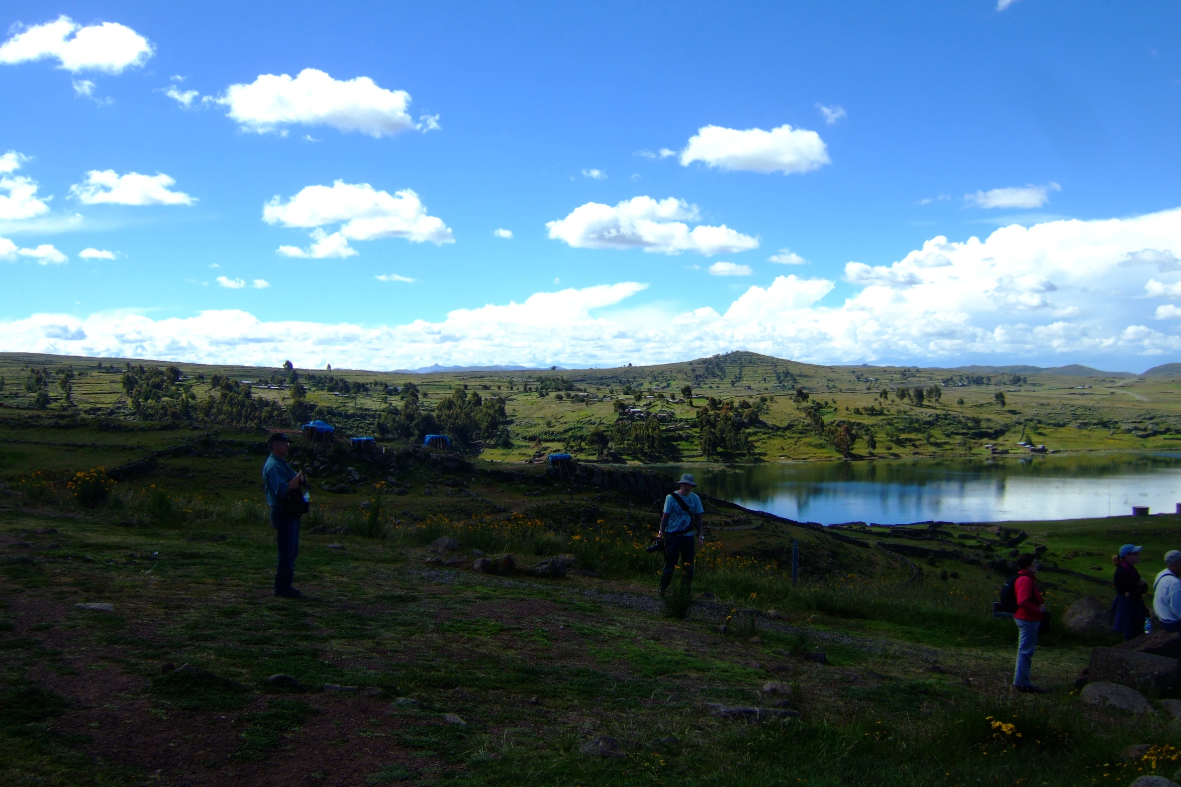 a bunch of people are on some hills by some water