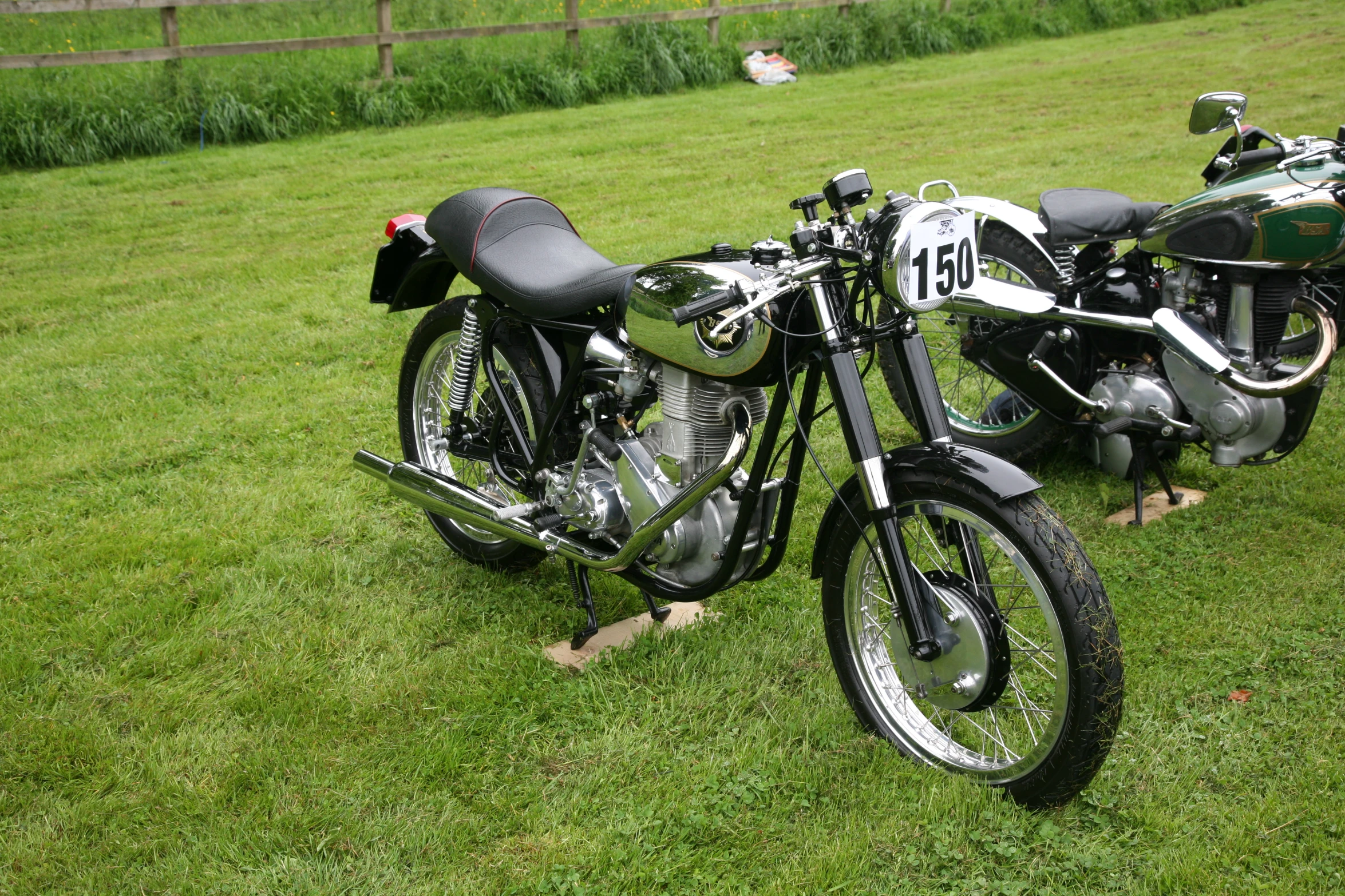 two motorcycles parked on the grass in the countryside