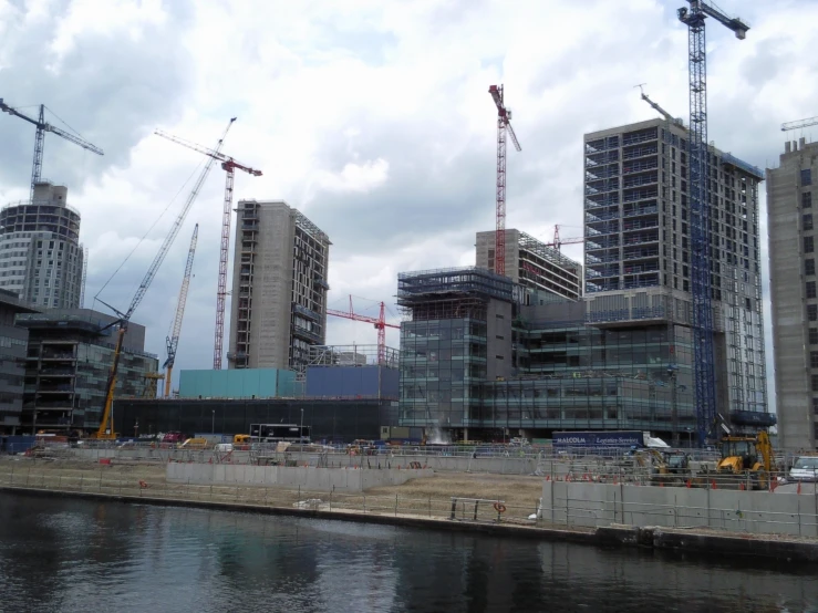 several large buildings under construction next to a body of water