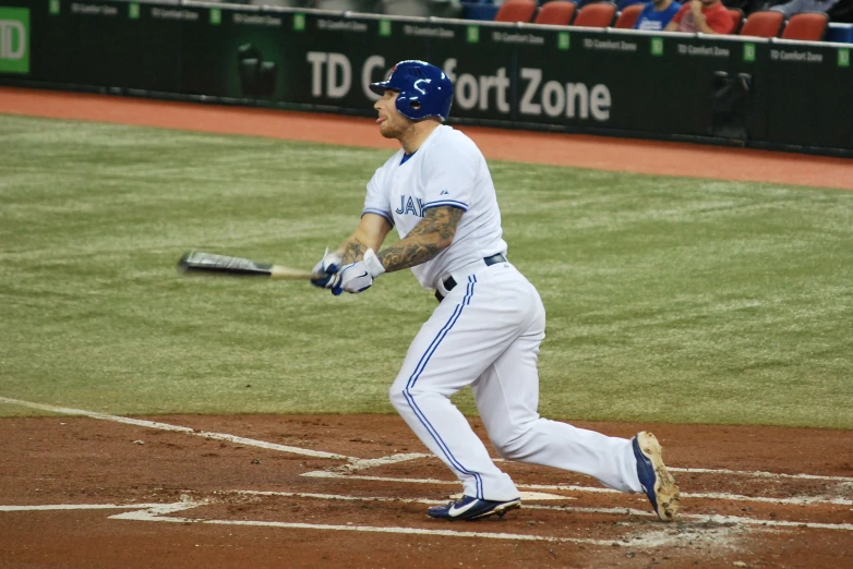 a man in baseball uniform swinging at a ball