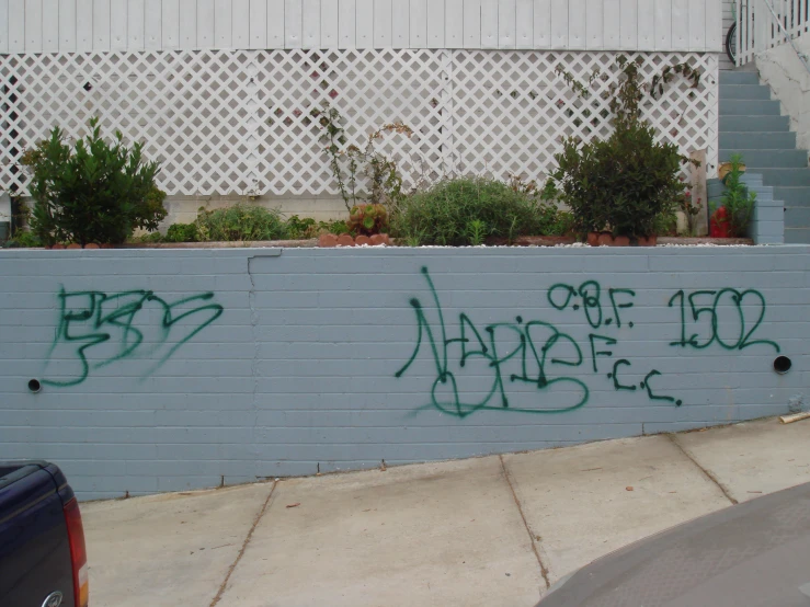 a blue wall with graffiti and letters painted on it