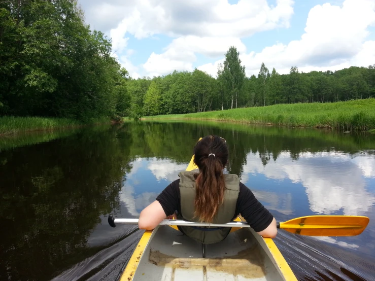 the girl is riding on a canoe through the water