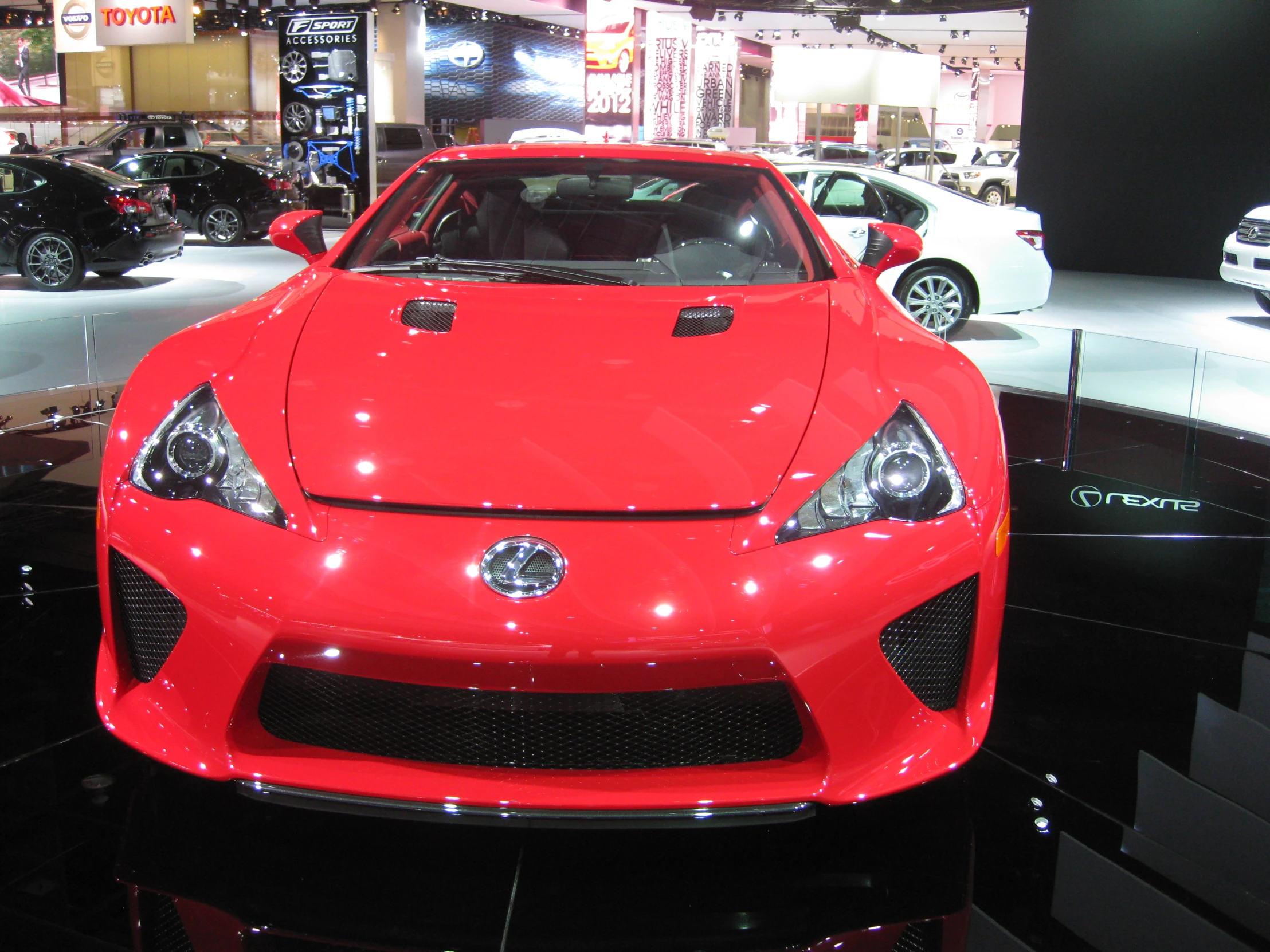 a red car is on display on the show floor