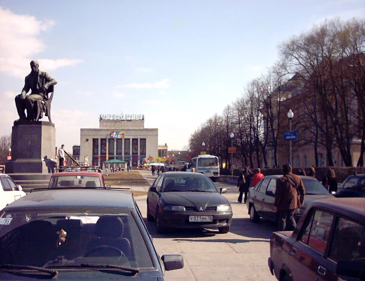 a large monument is in the background as cars are parked along a street