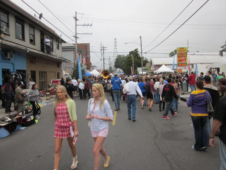 two blonde women walking in the middle of the street