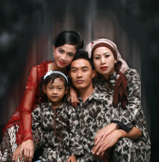 an asian family wearing matching clothing sitting next to each other