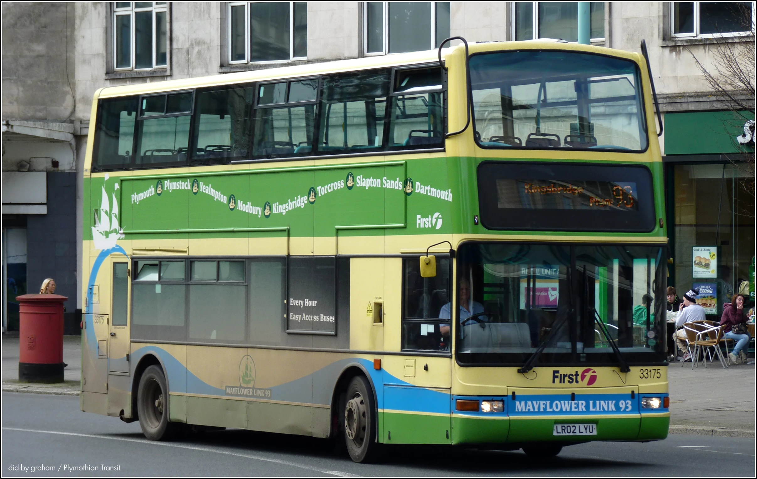 a double decker bus is going down the road