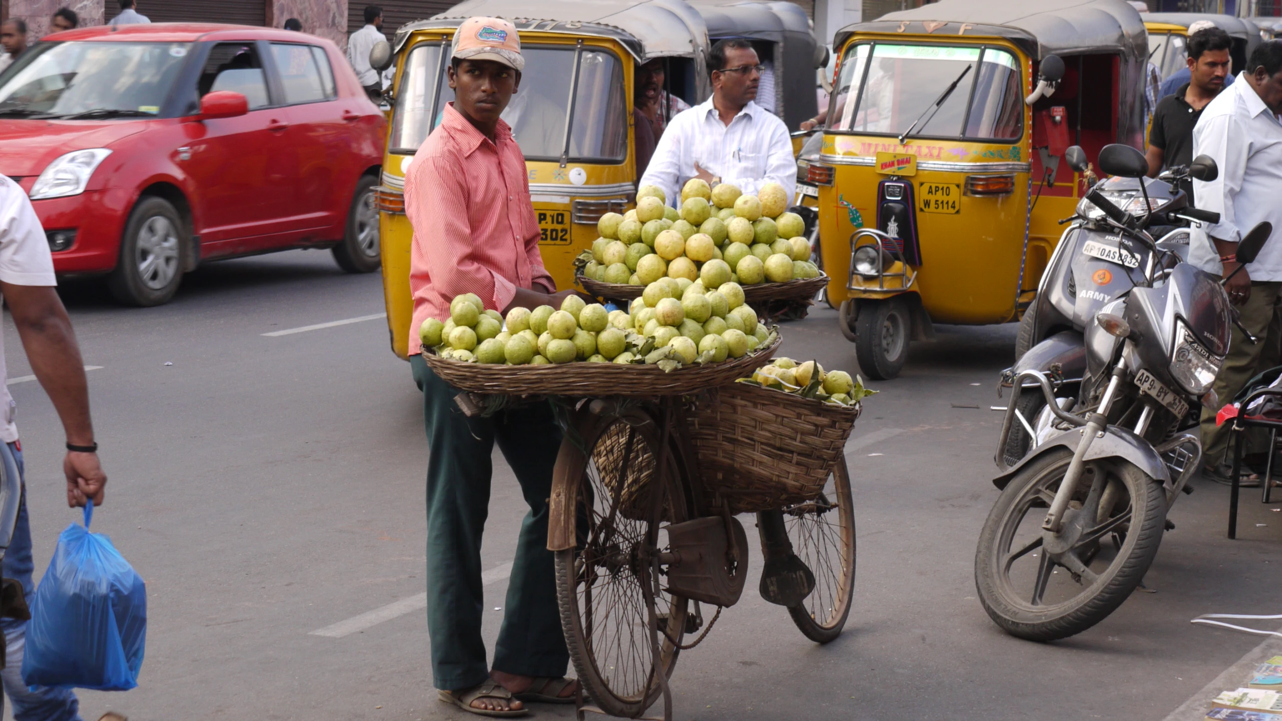 a woman carries a basket of bananas on a bicycle in traffic