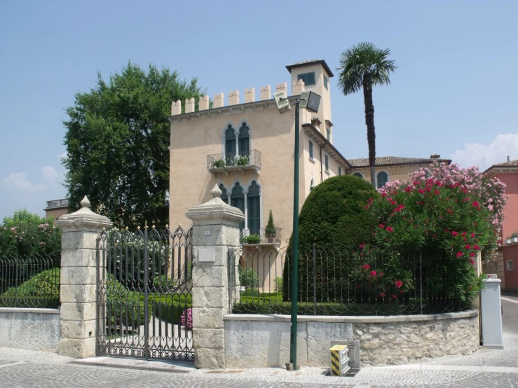 a pink house with iron gates and flowers