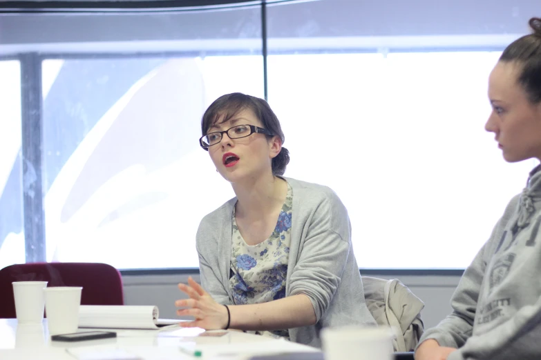 a woman sitting at a table with another person